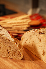 Fresh home made bread on the kitchen wood counter top. Vertical Photo a delicious sourdough bread got out of the oven. Bake bread at home.