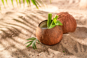 Healthy coconut milk in shell on a resort sandy beach.