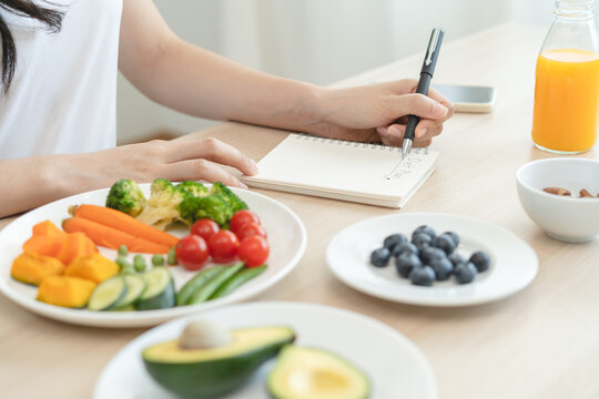 the person planning daily menu during dieting and writing diary to motivate.