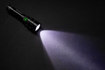 Flashlight and beam of light on a dark background