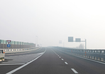 lane of motorway without cars but with a lot of dangerous fog which reduces visibility