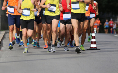 running race with feet and legs of many runners sports athletes - obrazy, fototapety, plakaty