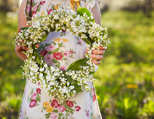 Little girl holding wreath from lily of the valley