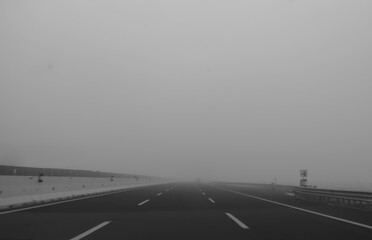 lots of fog and poor visibility while traveling on three-lane highway