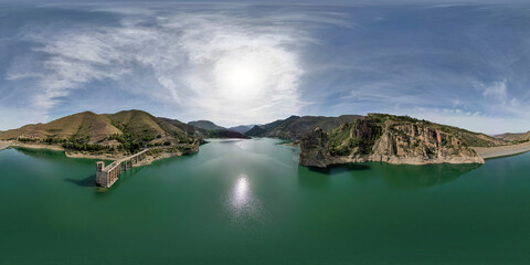 360 view. VR pano. Reservoir between mountains. Panoramic aerial view over the water of dam and...