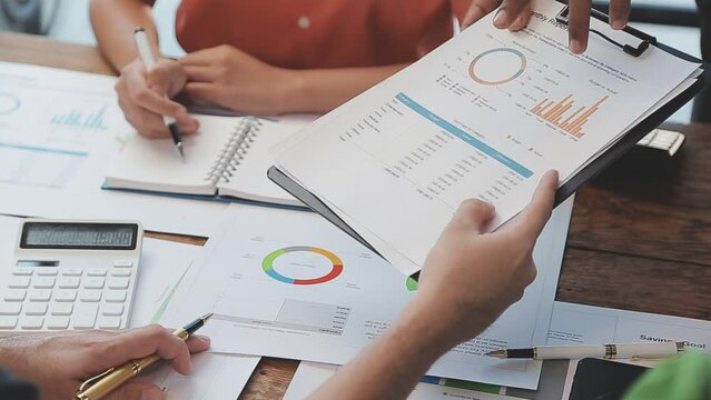 Close-up asia business people meeting plan analysis statistics brainstorm and header of team hold tablet pointing graph chart and employee take note. Finance strategy statistics success concept.