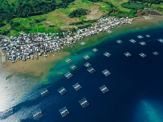 Indonesian fishing town and fishing boats in ocean on Sumbawa island. Scenic aerial view.