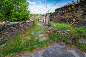 Campanario street, cobbled on slope with grass in El Espinar. Guadalajara. Spain. Europe.