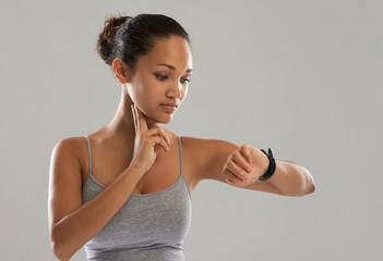 Woman, watch and checking pulse on neck for monitoring heartbeat against a gray studio background....