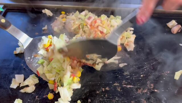 鉄板の上でもんじゃ焼きを焼く