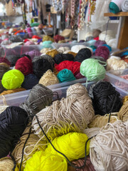 heap of colorful yarn balls or threads in knitting shop