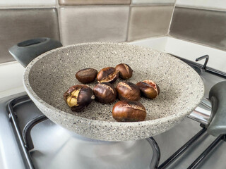 roasted chestnuts in a pan on stove in domestic kitchen