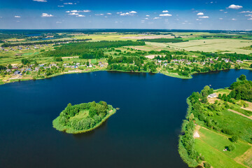 Aerial view of Ostrovno lakes, green fields and trees, small villages, summer on a sunny day, Belarus, Europe