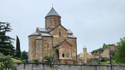 Obraz premium An exquisite church in Georgia showcases breathtaking ancient design, with intricate stone carvings, arched windows, and a timeless facade. Its historic charm stands proudly amidst Georgia's scenic la