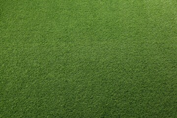 Green artificial grass as background, top view