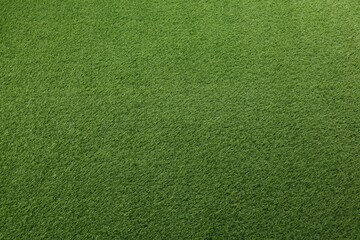 Green artificial grass as background, top view