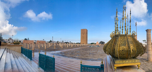 Rabat, Morocco, 04-05-2023: panoramic view of Hassan Tower, minaret of an incomplete mosque commissioned by the third Caliph of the Almohad Caliphate, and Mausoleum of Mohammed V and his two sons - obrazy, fototapety, plakaty