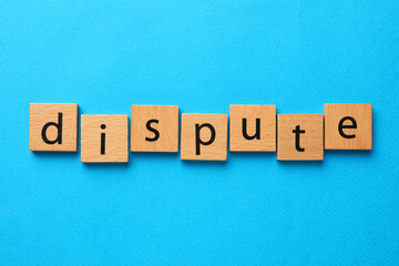 Word Dispute made with wooden cubes on light blue background, top view
