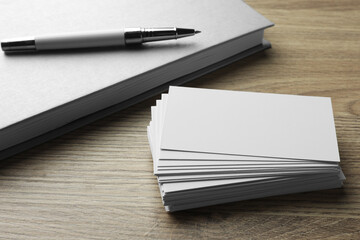 Stack of blank business cards, notebook and pen on wooden table. Mockup for design - obrazy, fototapety, plakaty