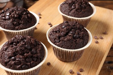 Tasty chocolate muffins on wooden table, closeup