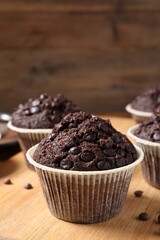 Tasty chocolate muffin on wooden board, closeup