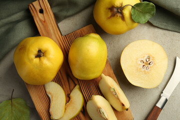 Tasty ripe quince fruits and knife on grey table, flat lay