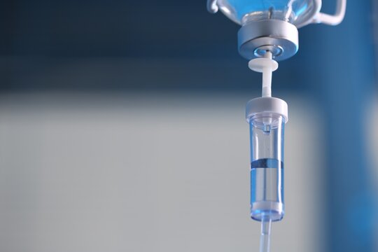 IV drip against blurred background, space for text