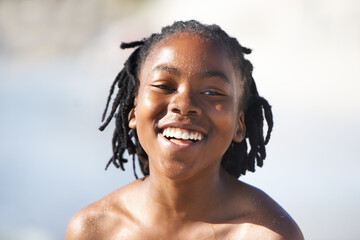 Face, black boy and happiness on beach with family for adventure, holiday or vacation in summer. African kid, face and smile outdoor in nature for break, experience or bonding with shirtless with fun - obrazy, fototapety, plakaty