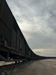 Obraz premium The freight train passes by the station. Wagons with goods delivery.