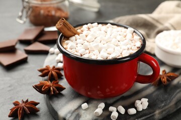 Tasty hot chocolate with marshmallows on dark textured table, closeup