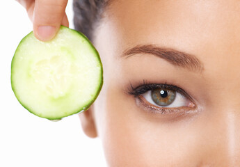 Woman, face and cucumber by eyes in beauty, facial or spa treatment on a white studio background....