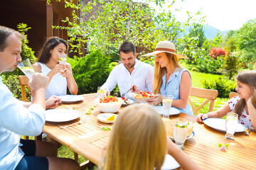 Family dinner variety of Italian dishes on wooden table in the garden