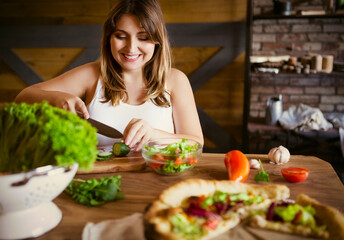 Young woman making vegetable salad