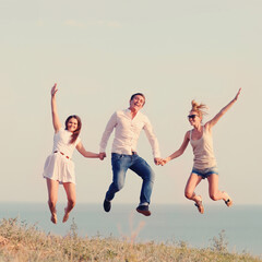 Fototapeta premium Happy friends jumping on the beach