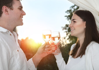 Young happy couple enjoying a glasses of white wine