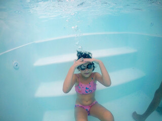 criança com óculos de natação diversão em água de piscina 