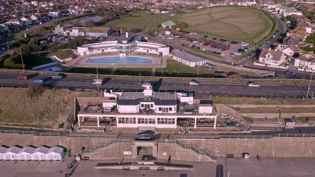 Aerial footage of the Saltdean art deco Lido and the WhiteCliffs Saltdean Cafe on the seafront in East Sussex England.