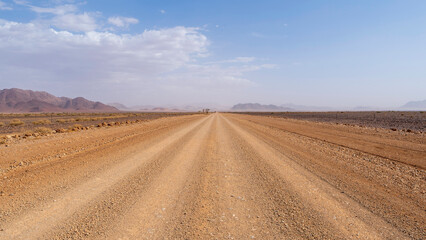 Driving through a gravel road inside Namibia and enjoying the astonishing surrounding scenery