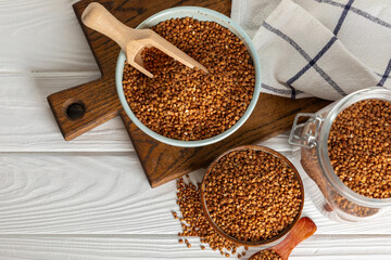 Raw buckwheat in a bowl on a textured background.Wheat grains, porridge, cereals, raw buckwheat in a plate. Healthy food. Porridge. Diet. Organic cerea. Space for text.Copy space.