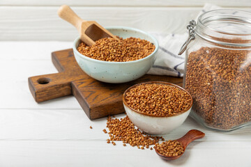 Raw buckwheat in a bowl on a textured background.Wheat grains, porridge, cereals, raw buckwheat in a plate. Healthy food. Porridge. Diet. Organic cerea. Space for text.Copy space.