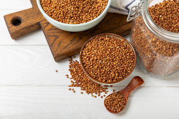 Raw buckwheat in a bowl on a textured background.Wheat grains, porridge, cereals, raw buckwheat in a plate. Healthy food. Porridge. Diet. Organic cerea. Space for text.Copy space.