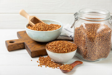 Raw buckwheat in a bowl on a textured background.Wheat grains, porridge, cereals, raw buckwheat in a plate. Healthy food. Porridge. Diet. Organic cerea. Space for text.Copy space.