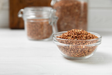 Raw buckwheat in a bowl on a textured background.Wheat grains, porridge, cereals, raw buckwheat in a plate. Healthy food. Porridge. Diet. Organic cerea. Space for text.Copy space.