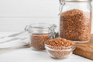 Raw buckwheat in a bowl on a textured background.Wheat grains, porridge, cereals, raw buckwheat in a plate. Healthy food. Porridge. Diet. Organic cerea. Space for text.Copy space.