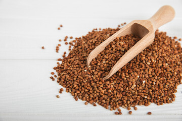 Raw buckwheat in a bowl on a textured background.Wheat grains, porridge, cereals, raw buckwheat in a plate. Healthy food. Porridge. Diet. Organic cerea. Space for text.Copy space.