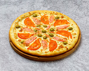 Homemade Italian style pizza with cheese, salmon, olives and tomato close-up on a wooden board on the table. Horizontal