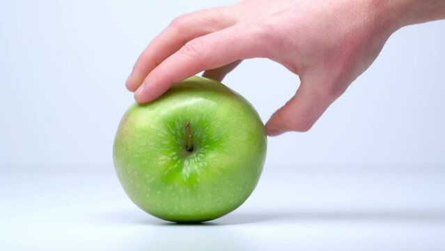 Spinning a green apple in slow motion on a white background