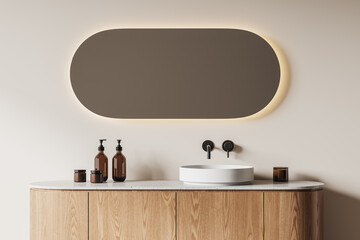 Sink and mirror in beige bathroom interior