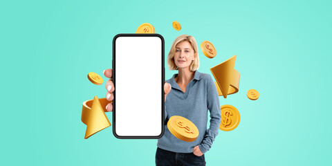 Woman showing mock up phone, golden coins on empty background, online payment