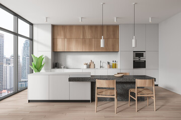 Stylish home kitchen interior with eating and cooking zone, panoramic window